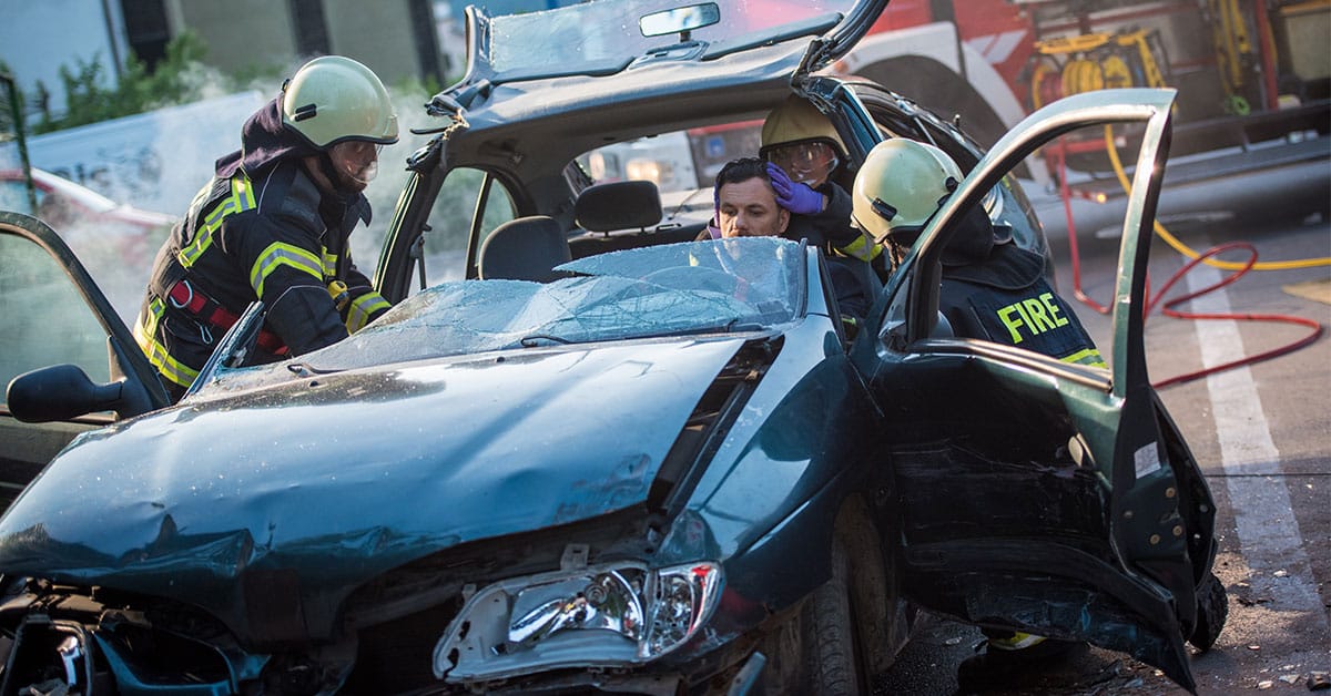 a person sitting on a motorcycle in front of a car