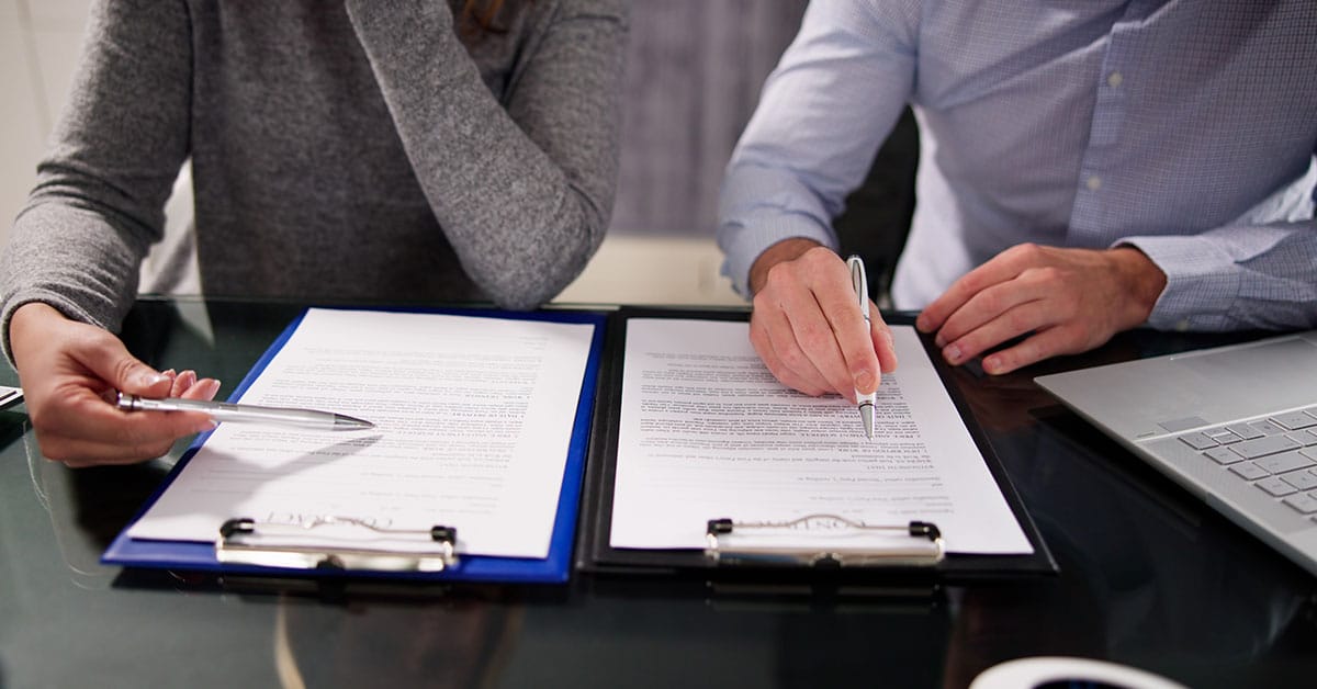 a person sitting at a table using a laptop computer