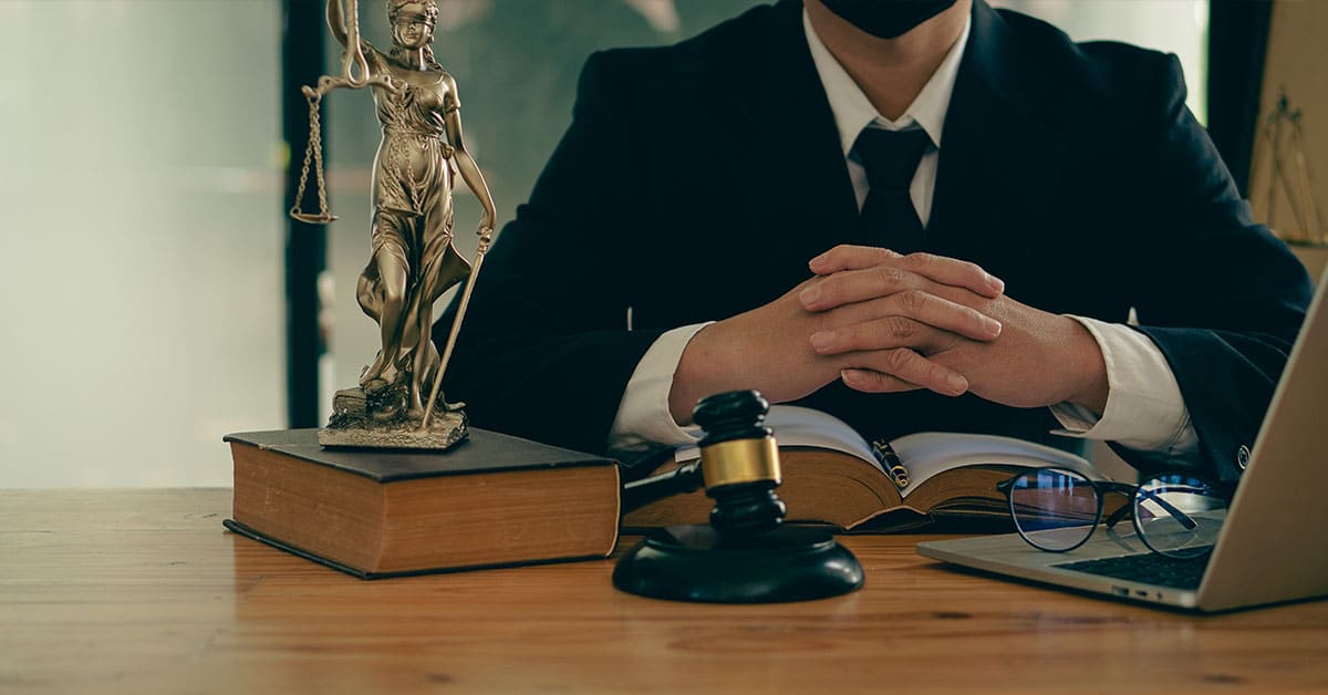 a man wearing a suit and tie sitting on a table